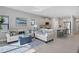 Open living room with light beige sofas, blue accents, and an adjacent kitchen at 364 Palmaria Ct, Nokomis, FL 34275