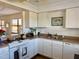 White kitchen cabinets, double sink, and electric range at 4104 Catalina Dr, Bradenton, FL 34210