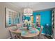 Dining area with round table, teal wall, and decorative art at 4106 Central Sarasota Pkwy # 1026, Sarasota, FL 34238