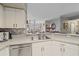 Kitchen with double sink, white cabinets, and view to living area at 4106 Central Sarasota Pkwy # 1026, Sarasota, FL 34238