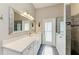 Modern bathroom with a white vanity, walk-in shower and large mirror at 4712 Compass Dr, Bradenton, FL 34208