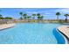 Community pool with lounge chairs and palm trees at 5762 Benevento Dr, Sarasota, FL 34238
