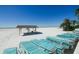 Beach view with lounge chairs and covered seating at 5830 Midnight Pass Rd # 406, Sarasota, FL 34242