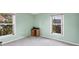 Bright bedroom with two windows, neutral walls, and carpeted floor at 6001 Cedarwood Ln, Bradenton, FL 34203