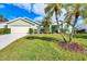 House exterior features a light green color, well-maintained lawn, and palm trees at 6001 Cedarwood Ln, Bradenton, FL 34203