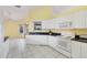 Kitchen with white cabinets, granite countertops, and access to the lanai at 6001 Cedarwood Ln, Bradenton, FL 34203