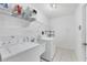 Laundry room with washer, dryer, shelving, and utility sink at 6001 Cedarwood Ln, Bradenton, FL 34203