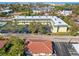Aerial view of a yellow building with parking lot, and neighboring houses at 6703 Midnight Pass Rd # 117, Sarasota, FL 34242