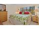 Tropical-themed bedroom with a king-size bed and wooden furniture at 6703 Midnight Pass Rd # 117, Sarasota, FL 34242