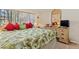 King-size bed with tropical bedding and wooden dresser at 6703 Midnight Pass Rd # 117, Sarasota, FL 34242