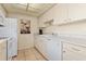 White cabinets, appliances, and countertops are featured in this galley-style kitchen at 6703 Midnight Pass Rd # 117, Sarasota, FL 34242