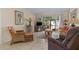 Living room with wicker furniture, a TV, and access to a screened patio at 6703 Midnight Pass Rd # 117, Sarasota, FL 34242