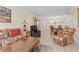 Living room with wicker furniture, a TV and access to screened patio at 6703 Midnight Pass Rd # 117, Sarasota, FL 34242