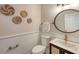 Stylish powder room with a round mirror and white wainscoting at 7800 18Th W Ave, Bradenton, FL 34209