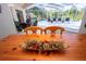 View of the pool from bright dining room with wooden table at 8532 Eagle Preserve Way, Sarasota, FL 34241