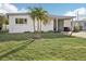 White, single-story home with carport, and green lawn at 1040 Roberta St, Venice, FL 34285