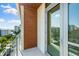 Private balcony featuring wood paneling and a glass railing with city views in the distance at 111 Golden Gate Pt # 403, Sarasota, FL 34236