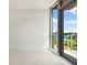 Bright bedroom featuring a glass patio door with views of the marina and waterfront at 111 Golden Gate Pt # 403, Sarasota, FL 34236