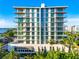 Modern condo building featuring floor-to-ceiling windows and private balconies overlooking lush tropical landscaping at 111 Golden Gate Pt # 403, Sarasota, FL 34236