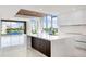 Modern kitchen with island, white cabinetry, and water views at 111 Golden Gate Pt # 403, Sarasota, FL 34236