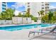 Relaxing pool with sun loungers and cabanas surrounded by lush greenery at 111 Golden Gate Pt # 403, Sarasota, FL 34236