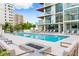 Beautiful outdoor pool area with a fire pit, sun loungers, and inviting cabanas at 111 Golden Gate Pt # 403, Sarasota, FL 34236