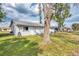 Backyard with patio, large tree, and a view of the neighboring house at 13479 Newport Ave, Port Charlotte, FL 33981