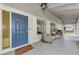 Covered porch with blue door, wicker chairs, and a grill at 13479 Newport Ave, Port Charlotte, FL 33981