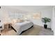 Bright bedroom features a window with blinds, hardwood floors, and a plant in the corner at 312 Yacht Harbor Dr, Osprey, FL 34229