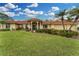 House with tile roof, palm trees, and a manicured lawn at 312 Yacht Harbor Dr, Osprey, FL 34229