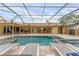 Large, screened-in pool and patio area with lounge chairs at 312 Yacht Harbor Dr, Osprey, FL 34229