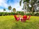 Red Adirondack chairs around a fire pit in grassy area at 4415 102Nd W St, Bradenton, FL 34210