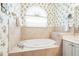 Relaxing bathroom with a garden tub and floral wallpaper at 4451 Legacy Ct, Sarasota, FL 34241