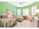 Bright bedroom with twin beds, a desk, and leafy patterned bedding at 4451 Legacy Ct, Sarasota, FL 34241