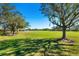 Green golf course with mature trees and houses in the background at 4451 Legacy Ct, Sarasota, FL 34241