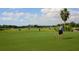Golfer putting on a lush green with a scenic background at 4451 Legacy Ct, Sarasota, FL 34241