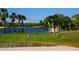 Golfers enjoying a putting green beside a lake with palm trees at 4451 Legacy Ct, Sarasota, FL 34241