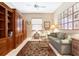 Spacious office with built-in wooden shelving and a comfortable seating area at 4451 Legacy Ct, Sarasota, FL 34241