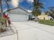 Exterior view of a home with a two-car garage, a concrete driveway and green grass at 4514 Sanibel Way, Bradenton, FL 34203