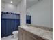 Clean bathroom with granite countertop and blue shower curtain at 7835 Hidden Creek Loop # 101, Lakewood Ranch, FL 34202