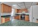 Kitchen boasts wood cabinets, green countertops, and a modern stovetop at 10307 Sandpiper W Rd, Bradenton, FL 34209