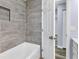 Modern bathroom with a bathtub and grey tile at 12302 Tangier St, North Port, FL 34287