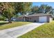 Single-story home featuring a long driveway, neutral stucco exterior, and attached garage at 12302 Tangier St, North Port, FL 34287