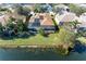 Aerial view of the home showcasing a sparkling lake, screened-in pool, solar panels, and lush green backyard at 13951 Wood Duck Cir, Lakewood Ranch, FL 34202