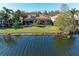 Aerial view of the home featuring a backyard with a tranquil lake, lush greenery, and a screened-in patio at 13951 Wood Duck Cir, Lakewood Ranch, FL 34202