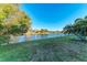 Expansive backyard with a tranquil lake view, mature trees, and well-maintained lawn, ideal for outdoor activities at 13951 Wood Duck Cir, Lakewood Ranch, FL 34202