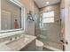 Modern bathroom features a stylish vanity with granite countertop and frameless glass shower with natural light at 13951 Wood Duck Cir, Lakewood Ranch, FL 34202
