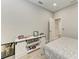 This bedroom has a barn door white credenza with pictures and decorations on top, along with light colored floors at 13951 Wood Duck Cir, Lakewood Ranch, FL 34202