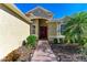 Inviting entryway with a red front door, brick pathway, and lush, manicured landscaping at 13951 Wood Duck Cir, Lakewood Ranch, FL 34202
