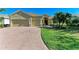 Front exterior of a single-Gathering home with a three-car garage and large driveway at 13951 Wood Duck Cir, Lakewood Ranch, FL 34202
